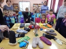 Малыши рассматривают выставку с рукавичками, варежками, перчатками для разных возрастов и профессий